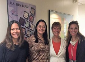 Standing in front of a US Dry Beans poster at the USDA Office in Sao Paulo, left to right: Fabiana Fonseca (USDA Agriculture Specialist), Gabriela Meucci (USDBC Brazil Consultant/Representative), Ellen Levinson (USDBC International Representative for the Americas and Emerging Markets), Chanda Berk (FAS Sao Paulo)